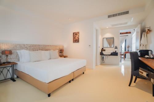 een slaapkamer met een groot wit bed en een bureau bij Xinlor House - Phuket Old Town in Phuket