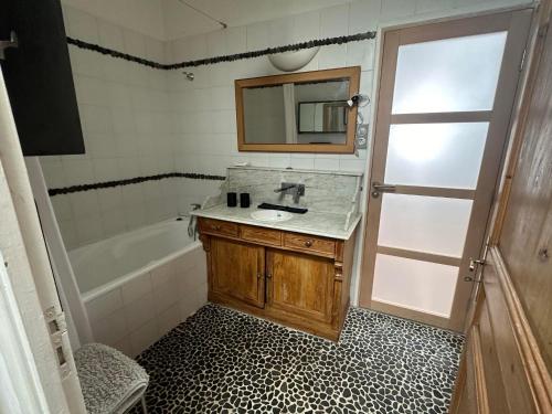 une salle de bain avec un lavabo, une baignoire et un miroir dans l'établissement Appartement de charme Intra Muros, à Avignon