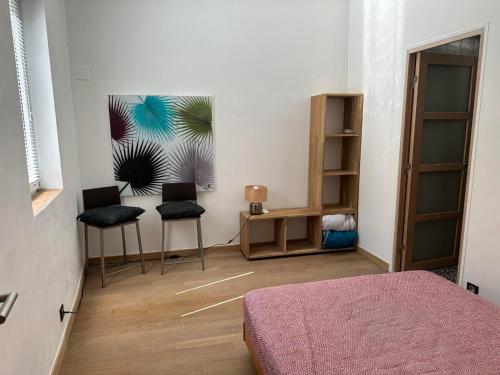 - une chambre avec deux chaises, un lit et une table dans l'établissement Appartement de charme Intra Muros, à Avignon
