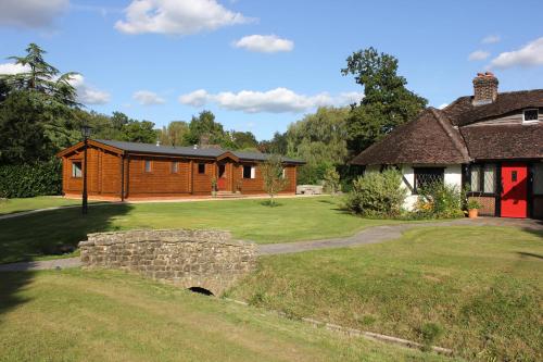 a house with a stone wall in front of a yard at The Lodge in Storrington