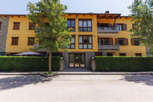 a yellow building with a tree in front of it at SantPauLux in Sant Pau de Seguries