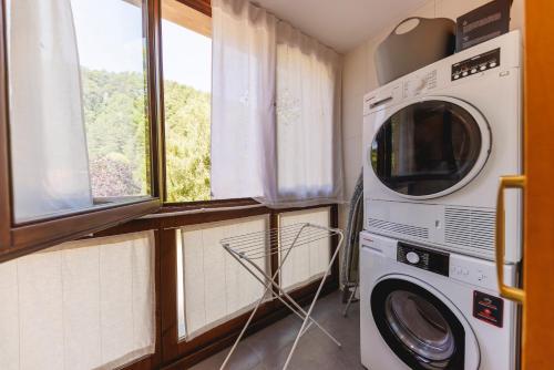 a washer and dryer in a room with a window at SantPauLux in Sant Pau de Seguries