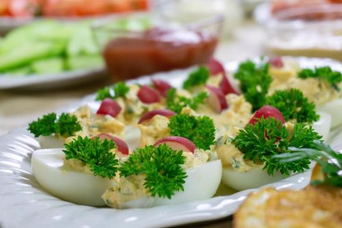 a plate of deviled eggs with parsley and other vegetables at Hotel Hesperus in Międzyrzec Podlaski