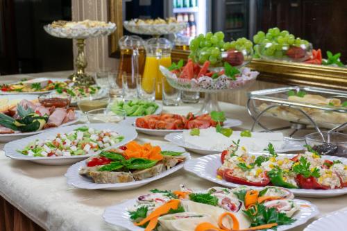 a table with many plates of food on it at Hotel Hesperus in Międzyrzec Podlaski