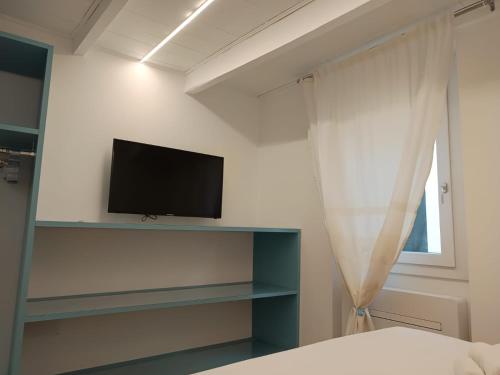 una camera da letto con una TV a schermo piatto su una parete di Loft Delitala 1 ad Alghero