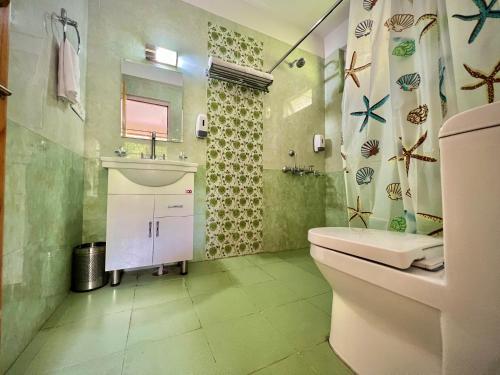 a bathroom with a sink and a toilet and a shower at Urban Monk Stays and Cafe in Manāli