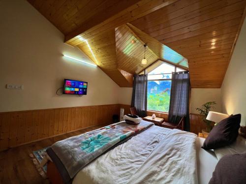 a bedroom with a bed in a room with a window at Urban Monk Stays and Cafe in Manāli
