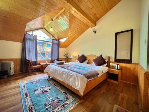 a bedroom with a large bed and a large window at Urban Monk Stays and Cafe in Manāli