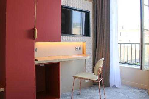 a room with a desk and a chair and a window at Brit Hotel Limoges Centre Gare - Hôtel & Spa in Limoges
