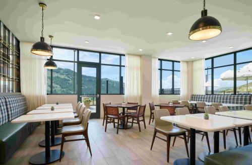 a restaurant with tables and chairs and windows at TownePlace Suites by Marriott Avon Vail Valley in Avon