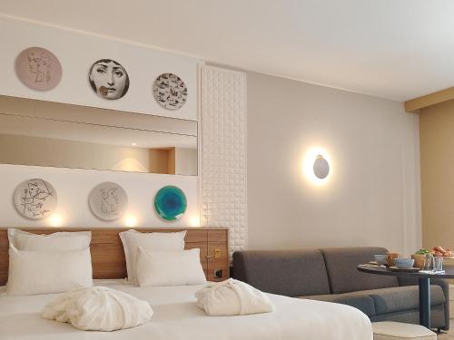a bedroom with a bed and a chair and a mirror at Brit Hotel Limoges Centre Gare - Hôtel & Spa in Limoges