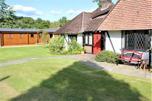 a house with a red bench in the yard at The Lodge in Storrington