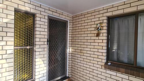 a brick wall with two windows in a room at Big Holliday house with pool in Brisbane