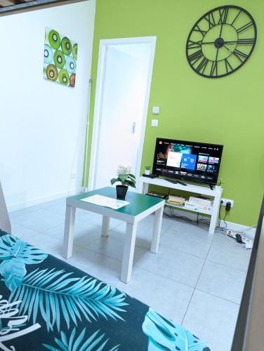 a living room with a table and a tv at Appartement entier meublé à Beaumont proche Futuroscope et Poitiers Technopole in Beaumont