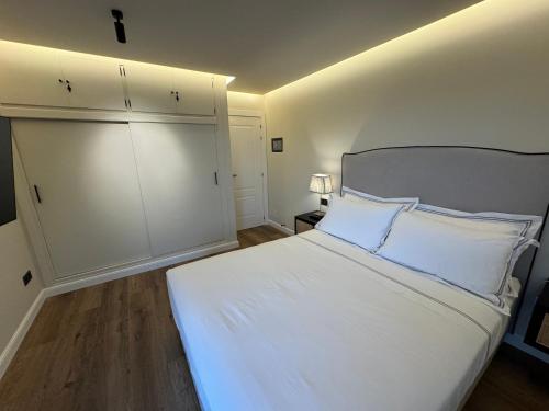 a bedroom with a large white bed with white pillows at Villa Harmony in Mijas Costa