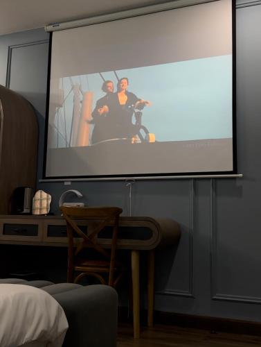 a projection screen with two people on it in a room at The Palette Dalat in Da Lat