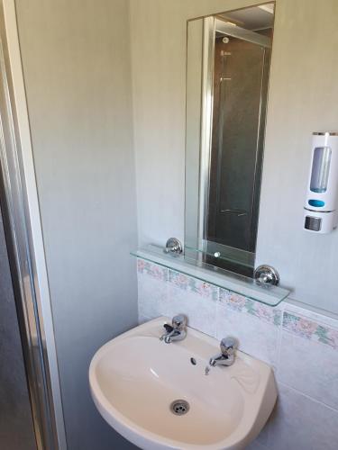 a white sink in a bathroom with a mirror at 8 Berth Northshore Skegness The Cottage Panel heated in Lincolnshire