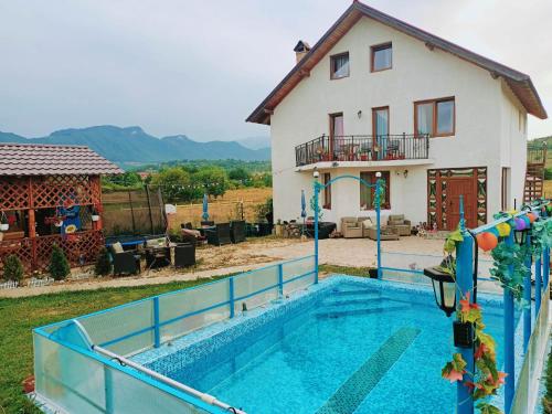 a house with a swimming pool in front of a house at Cazare Haiducita Bran in Zărneşti