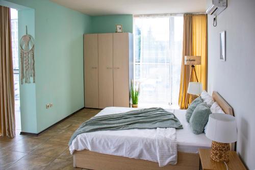a bedroom with a bed and a large window at Апартамент FLAME in Sunny Beach