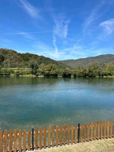 a view of a river with a wooden fence at Vukova Brvnara in Drlače