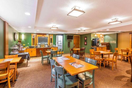 a dining room with wooden tables and chairs at AmericInn by Wyndham Monmouth in Monmouth
