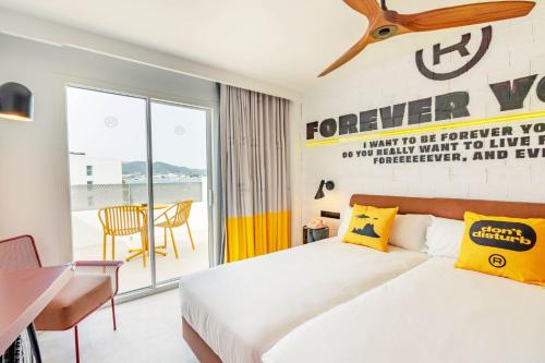 a bedroom with a bed and a desk and a window at Ryans Lolas - Adults Only in San Antonio Bay