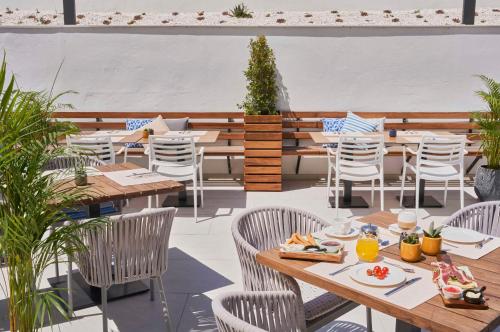 an outdoor dining area with tables and chairs at Barceló Conil Playa - Adults Recommended in Conil de la Frontera