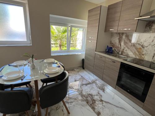 une cuisine avec une table et des chaises dans une cuisine dans l'établissement Appartement Cosy, à Yutz