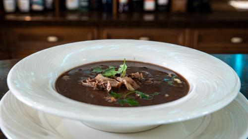 a bowl of soup on a plate on a table at Boutique Odyseja & Spa in Ciechocinek
