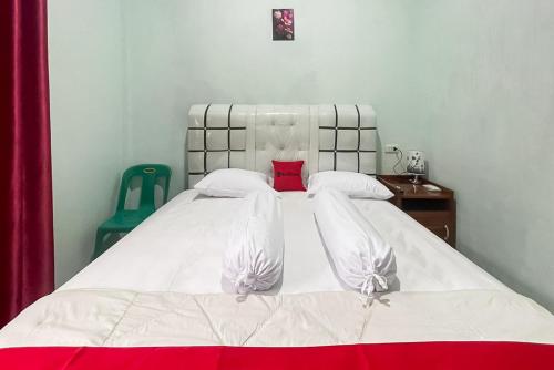 a bedroom with a large white bed with red pillows at RedDoorz near Kantor Bupati Tapanuli Tengah Aek Tolang in Halangan
