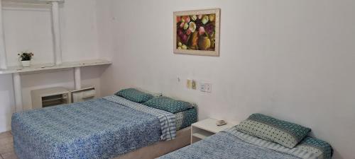 a bedroom with two beds and a picture on the wall at Hotel Recanto da lagoa in Juazeiro do Norte