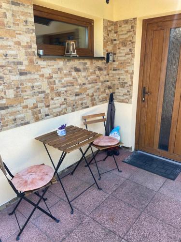 a table and two chairs sitting next to a door at Liptov Odessa in Liptovský Mikuláš