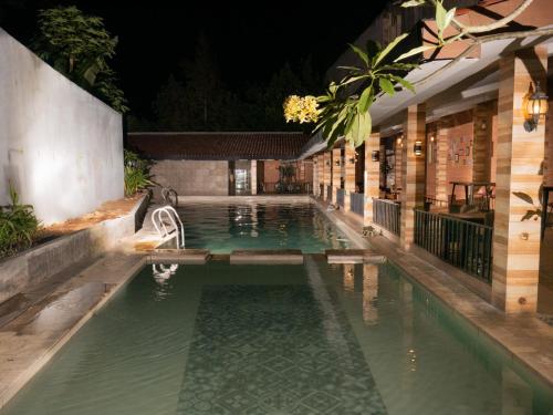 a swimming pool in a building at night at Meotel Purwokerto in Purwokerto