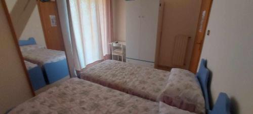 a small bedroom with two beds and a window at B&B da Maria & Renato il Lago Trattoria in Mirabella Eclano