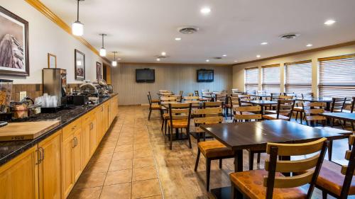a restaurant with tables and chairs and a bar at Best Western Plus Country Meadows Inn in Aldergrove