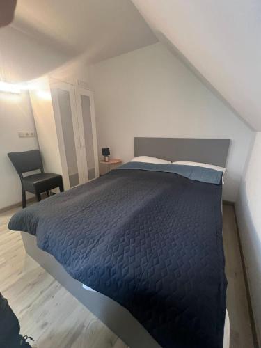 a bedroom with a bed and a chair in it at Upper-House Goldener Hirsch in Aystetten