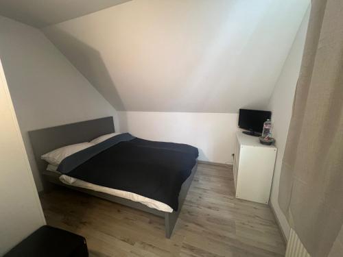 a small bedroom with a bed in a attic at Upper-House Goldener Hirsch in Aystetten