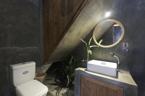 a bathroom with a toilet and a sink and a mirror at Bara Beach Home in Galle