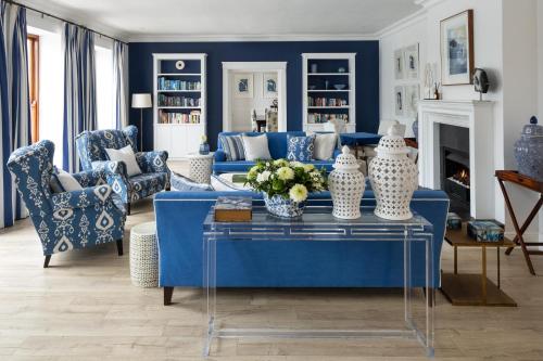 a blue living room with a blue couch and chairs at The Plettenberg Hotel in Plettenberg Bay