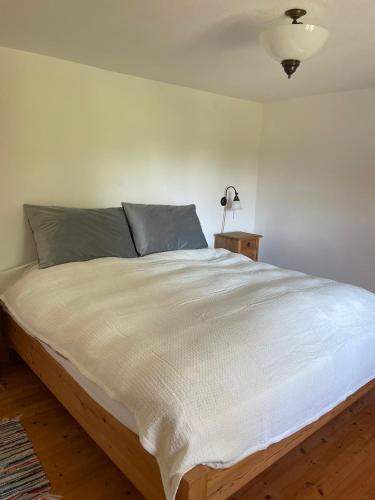 a large bed in a bedroom with a white wall at Landhof Rupertsdorf in Seeon