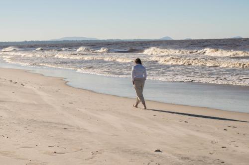 a woman walking on the beach near the ocean at Las Madres Selvas in Las Toscas