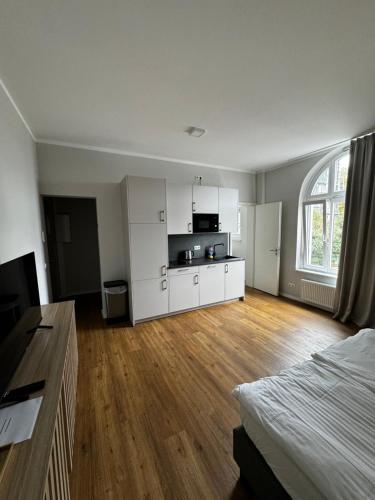 una habitación vacía con una cama y una cocina y una habitación con una cama cuadrada en Hamburg Hafen Wohnung, en Hamburgo