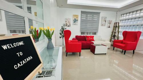 a living room with red chairs and a red couch at CazaTara - Modern Villa with Pool in Alaminos in Alaminos