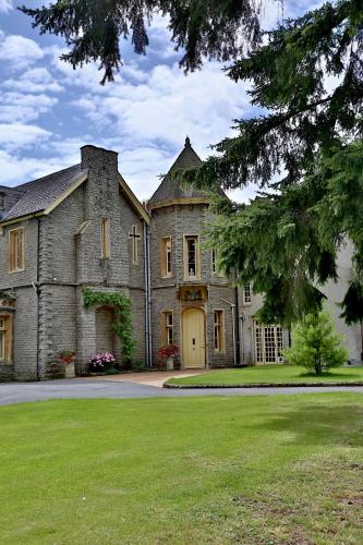 a large stone house with a large yard at Llangattock Park House in Crickhowell