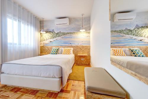 ein Schlafzimmer mit 2 Betten und einem Wandgemälde in der Unterkunft Hotel do Mercado in Aveiro