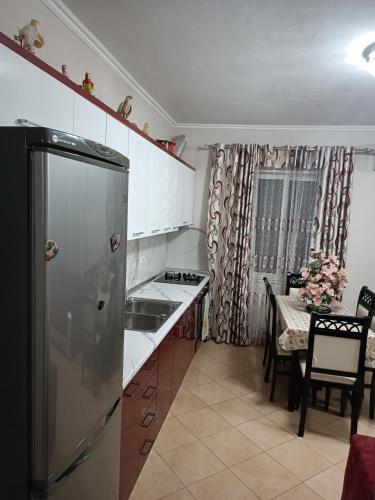 una cucina con frigorifero in acciaio inox e un tavolo di Denada Apartment a Durrës