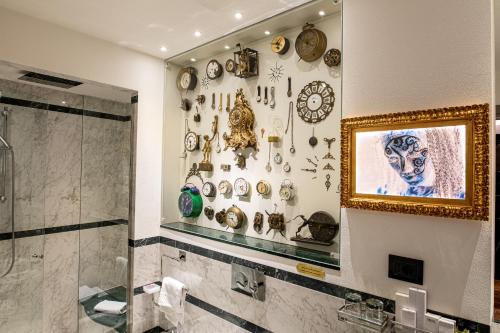 a bathroom with a shower and a bunch of clocks on the wall at Art Hotel Commercianti in Bologna
