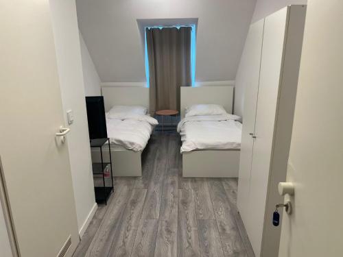 two beds in a small room with a window at Upper-House Goldener Hirsch in Aystetten