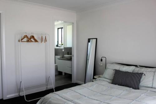 a bedroom with a bed and a bathroom with a sink at Brand New Luxury Build with Home Theatre in Kelso
