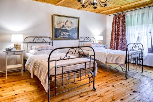 2 łóżka w sypialni z drewnianym sufitem w obiekcie Hanna House w Świeradowie Zdroju
